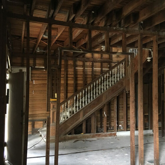 Work in progress: stair hall stripped to bare studs and ceiling joists with temporary support posts