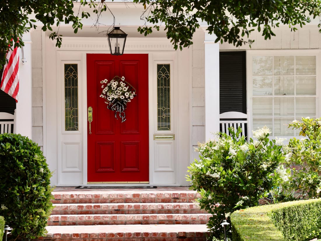 Historic home exterior restoration with red front door and columned porch, M&M Homes, Jacksonville