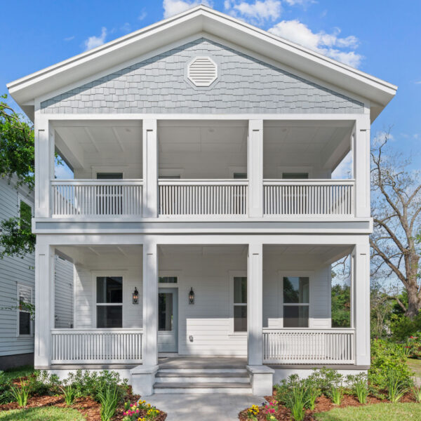 New construction two story home with stacked front porches and a gable roof in a Jacksonville neighborhood