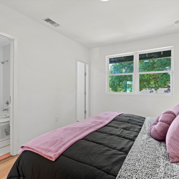 016-modernized-apartment-bedroom-layout Bright apartment bedroom renovation showing clean luxury finishes and architectural trim.