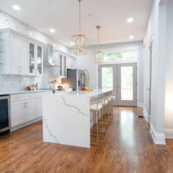 02-classic-colonial-kitchen-heart-pine-flooring Kitchen with a marble topped island and restored heart pine flooring running toward rear glass doors