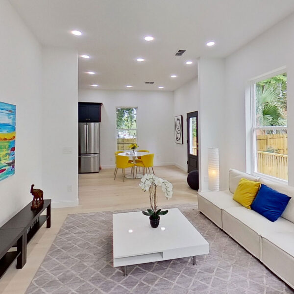 05-magnolia-living-room-sectional-view-toward-kitchen Living room sectional and artwork with sight lines running back to the kitchen in this three bedroom plan