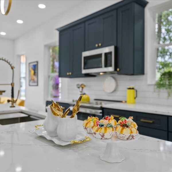 Styled kitchen counter detail with navy shaker cabinets and a tile backsplash in soft focus