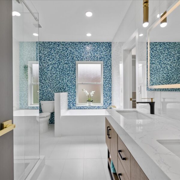 Full bathroom featuring a built in tub a blue mosaic accent wall and a wood double vanity