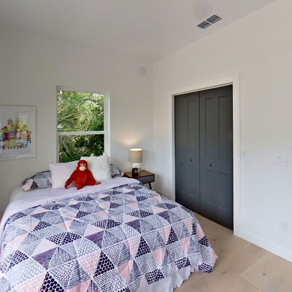 10-magnolia-bedroom-double-closet-doors-hallway-view Bedroom with double closet doors and a shaded window view beside an open hallway doorway