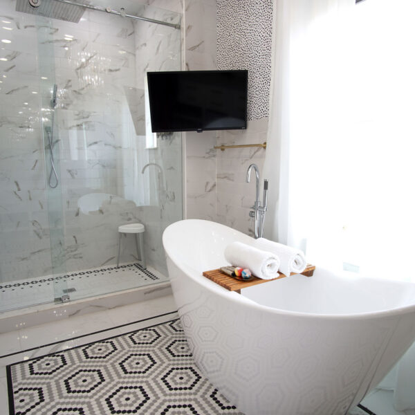 11-shotgun-house-bathroom-soaking-tub-mosaic-tile-floor Spa style bath pairing a freestanding soaking tub with a glass shower and hexagon mosaic tile flooring