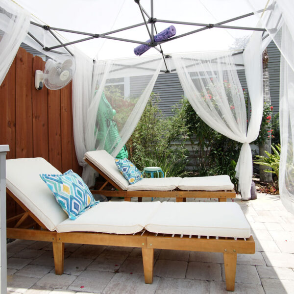 15-shotgun-house-poolside-cabana-lounge-chairs Cushioned chaise loungers rest under a curtained cabana on the paver patio beside the pool