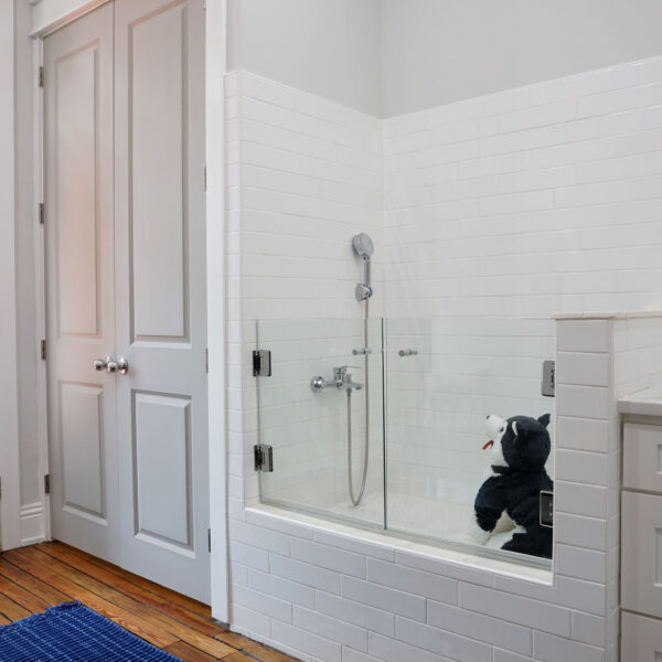16-classic-colonial-laundry-room-dog-washing-station Laundry room dog washing station with a tiled step in basin and a glass splash panel