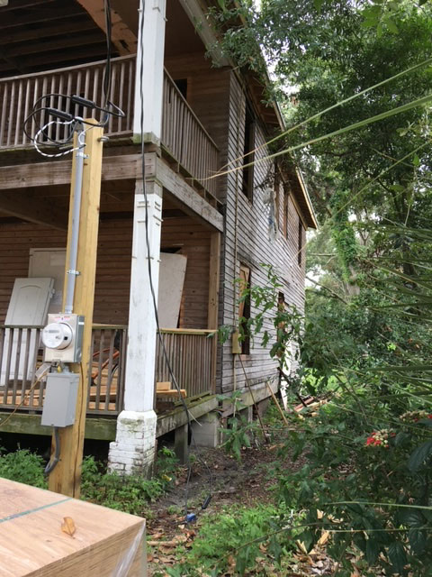 classic-colonial-before-weathered-siding-side-elevation-jacksonville-mnm-homes-04-01 Before restoration: side elevation with weathered siding open window openings and a temporary power post