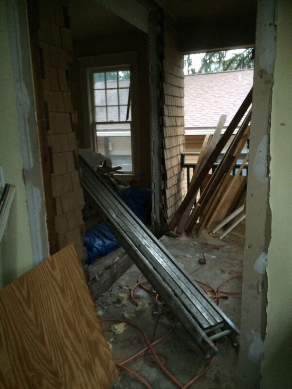 fireplace-house-during-opened-wall-stripped-floor-jacksonville-mnm-homes-01-08 Work in progress: room with the wall opened up and the floor stripped down beside stacked lumber