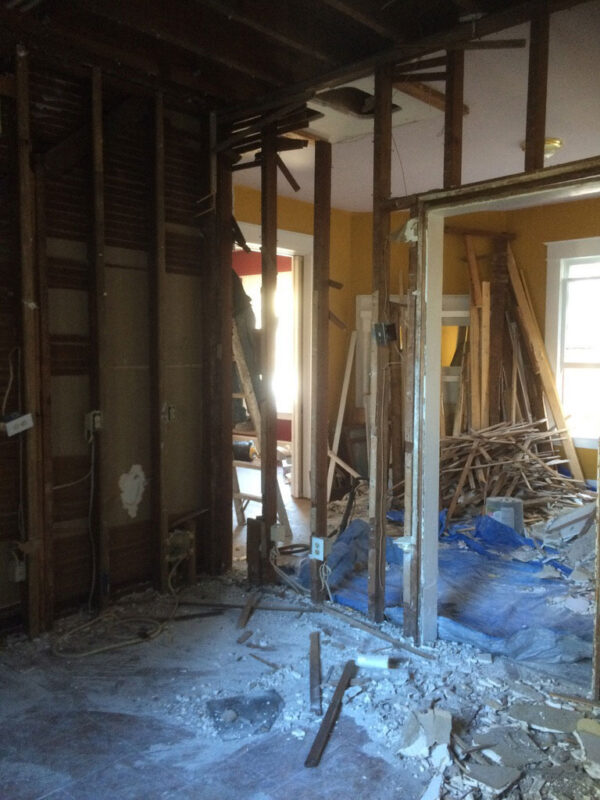 fireplace-house-during-stripped-interior-framing-jacksonville-mnm-homes-01-03 Work in progress: interior demolition with walls opened to the original framing and debris on the floor