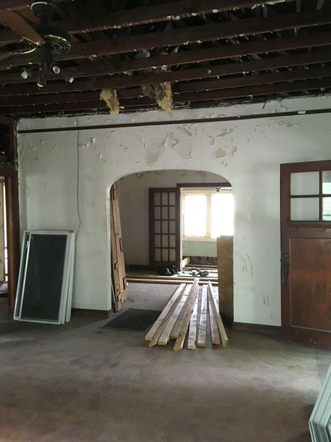 modern-farmhouse-during-ceiling-demolition-exposed-joists-jacksonville-mnm-homes-07-06 Renovation in progress: ceiling removed to expose framing joists with new lumber stacked on the bare floor