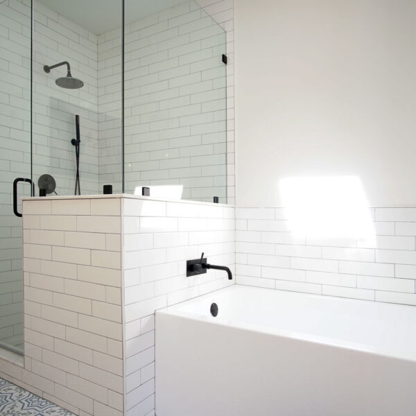 modern-farmhouse-ensuite-shower-tub-jacksonville-mnm-homes-10 Glass enclosed shower and soaking tub finished in white subway tile above patterned floor tile