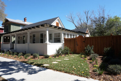 White 1935 ranch bungalow with a deep covered porch and new fencing in a historic Jacksonville FL neighborhood