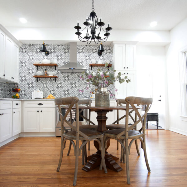 modern-farmhouse-kitchen-open-shelving-jacksonville-mnm-homes-05 Kitchen and dining area with a vent hood open shelving and a round table beneath a black chandelier