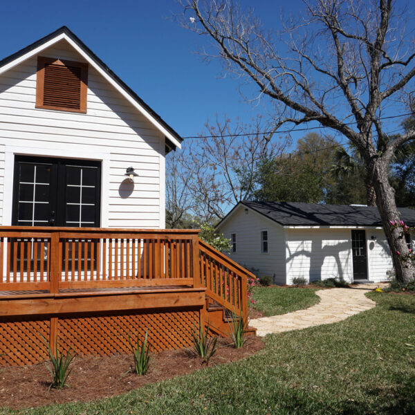 modern-farmhouse-rear-deck-jacksonville-mnm-homes-16 Rebuilt rear deck and detached outbuilding at the back of the restored 1935 bungalow under blue sky