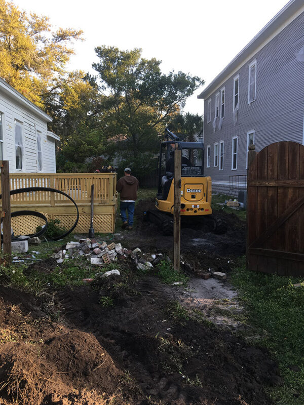 shotgun-house-before-rear-yard-excavation-jacksonville-mnm-homes-03-02 Before renovation: rear yard excavated with a compact excavator and a pile of broken masonry
