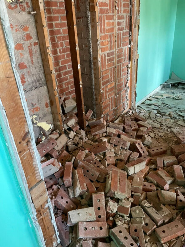 zen-garden-during-collapsed-brick-partition-wall-jacksonville-mnm-homes-05-05 Work in progress: collapsed interior brick wall spilling onto the floor beside exposed wall framing