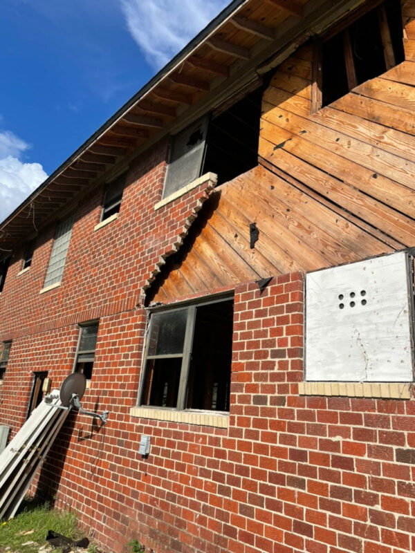 zen-garden-during-exposed-wall-sheathing-jacksonville-mnm-homes-05-02 Work in progress: exterior wall with brick veneer removed exposing wood sheathing and open window frames