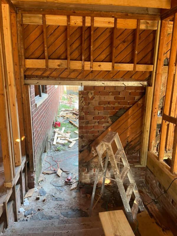 zen-garden-during-framed-doorway-worksite-jacksonville-mnm-homes-05-13 Work in progress: framed door opening with a stepladder work light and cut lumber on the site beyond