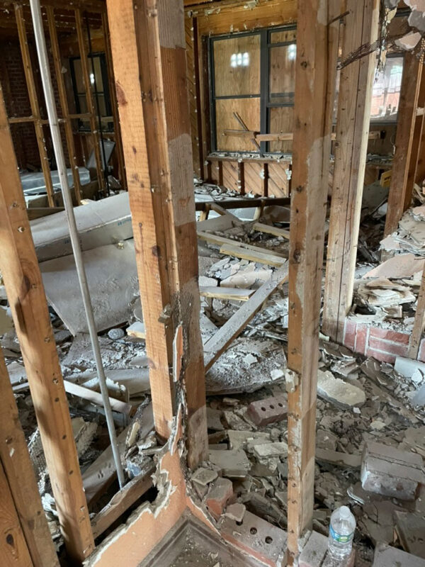 zen-garden-during-gutted-unit-interior-rubble-jacksonville-mnm-homes-05-12 Work in progress: gutted interior with exposed framing and plaster and brick rubble across the floor