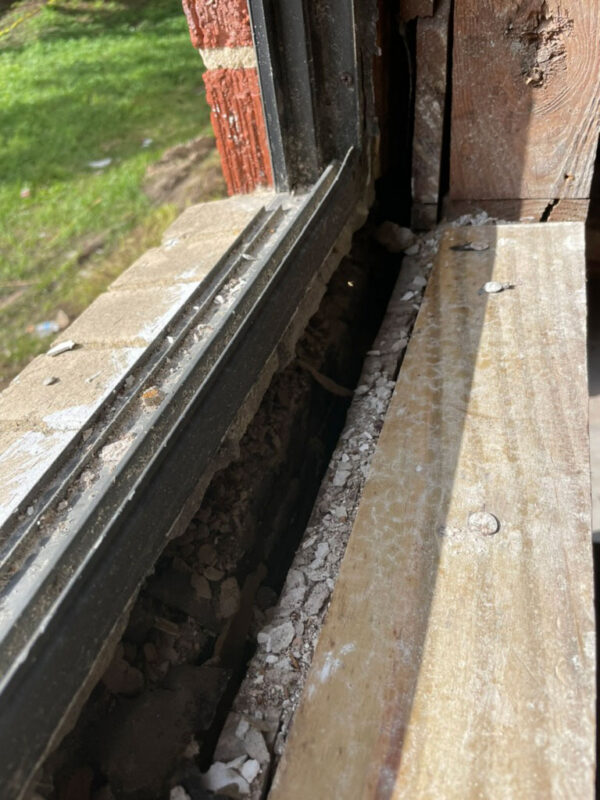 zen-garden-during-opened-window-sill-framing-jacksonville-mnm-homes-05-09 Work in progress: close view of an opened window sill showing wood framing and loose masonry debris
