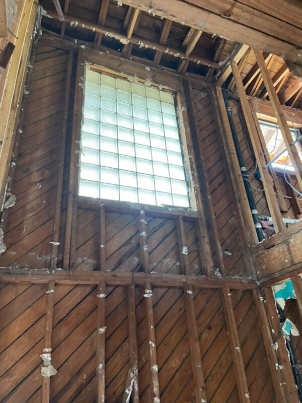 zen-garden-during-stripped-wall-glass-block-window-jacksonville-mnm-homes-05-11 Work in progress: stairwell wall stripped to diagonal board sheathing around a glass block window